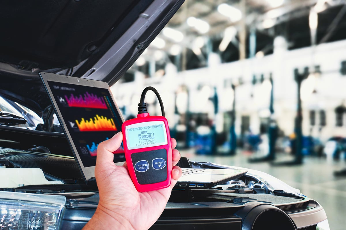 OBD diagnostic scanner and laptop reading a car engine system at 1st Wheels Garage